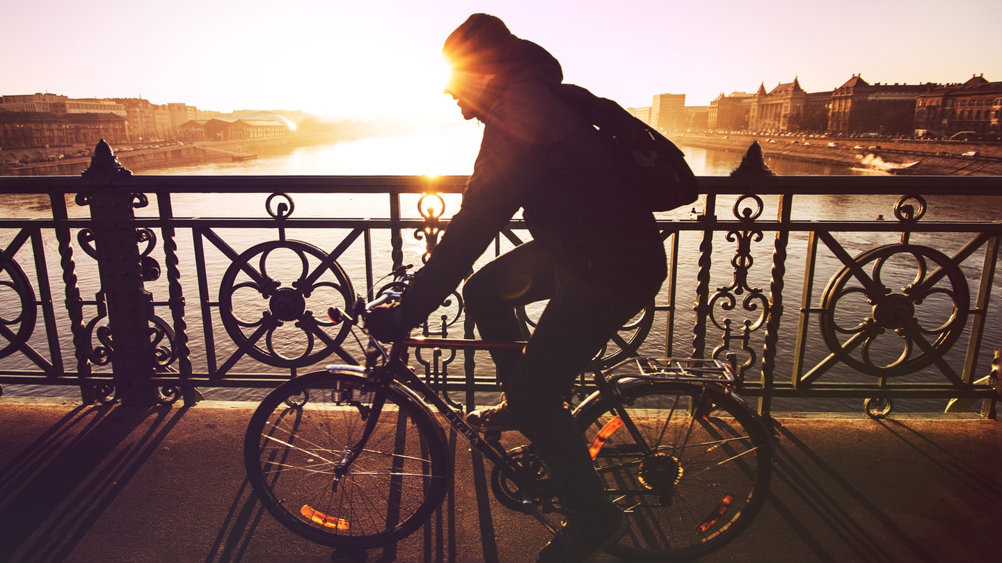 Ciclista cruzando el Puente de la Libertad de Budapest sobre el Danubio
